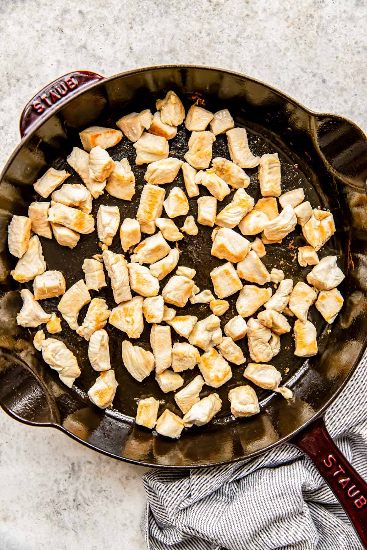 browned chicken pieces in a cast iron skillet