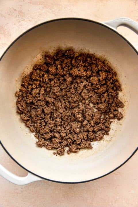 ground beef crumbled into smaller pieces in dutch oven