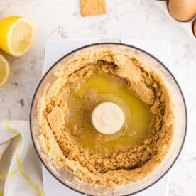 melted butter poured into food processor with crushed up shortbread cookies