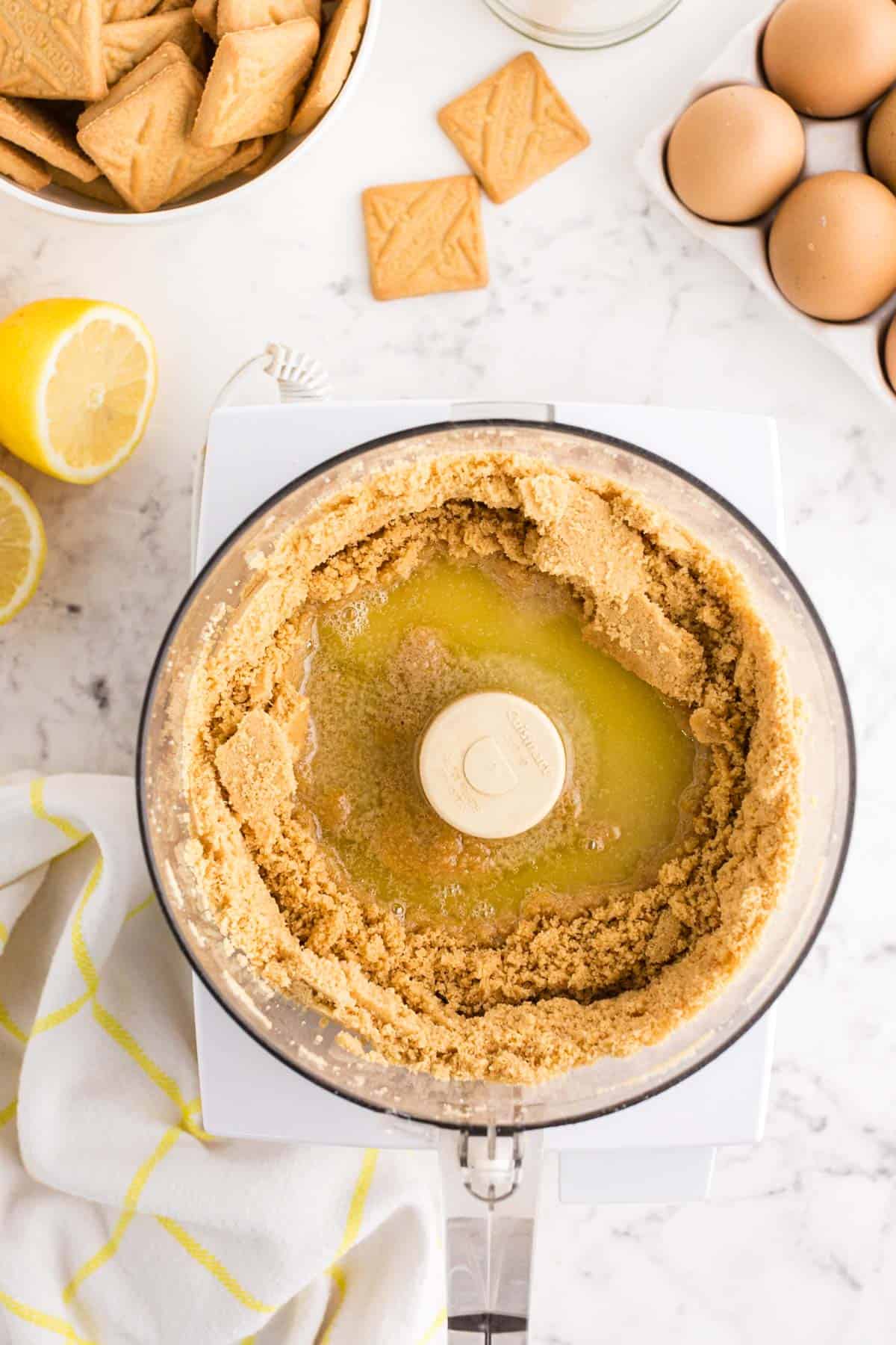 melted butter poured into food processor with crushed up shortbread cookies