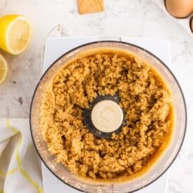 lemon tart crust mixture mixed together in the bowl of a food processor