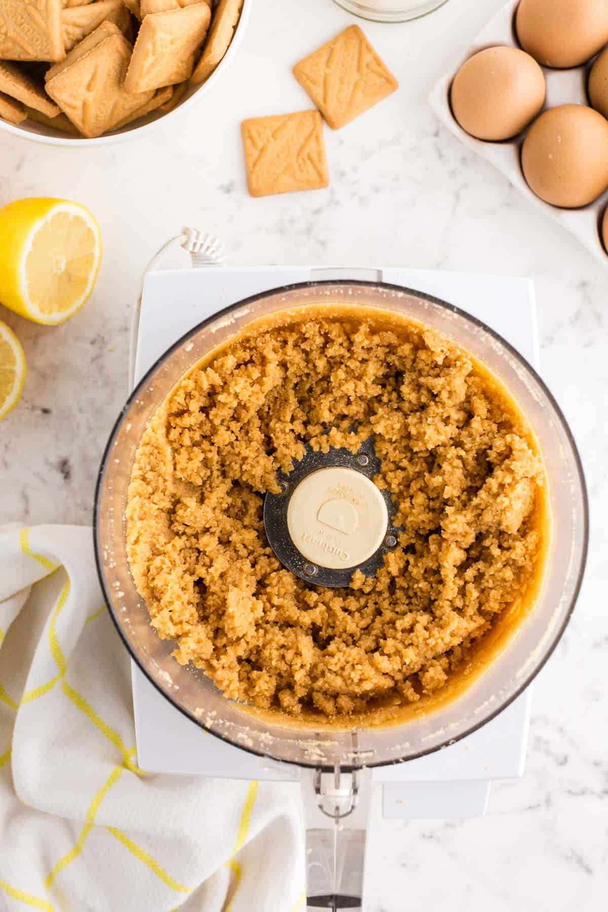 lemon tart crust mixture mixed together in the bowl of a food processor