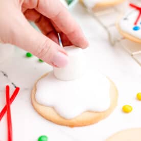 a marshmallow is being placed on top of the icing