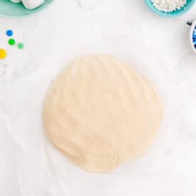 cookie dough formed into a disc on parchment paper