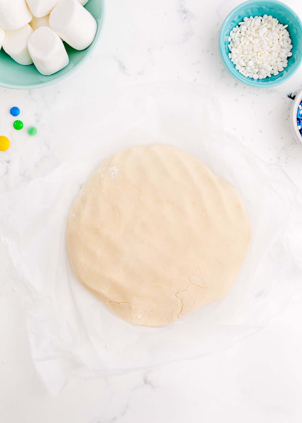 cookie dough formed into a disc on parchment paper