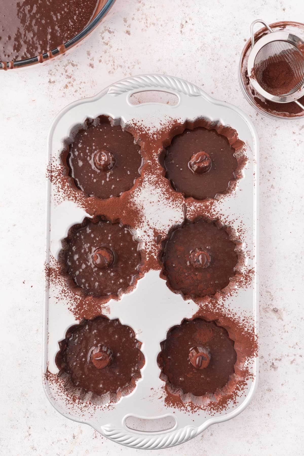 mini bundt pans are filled with chocolate batter