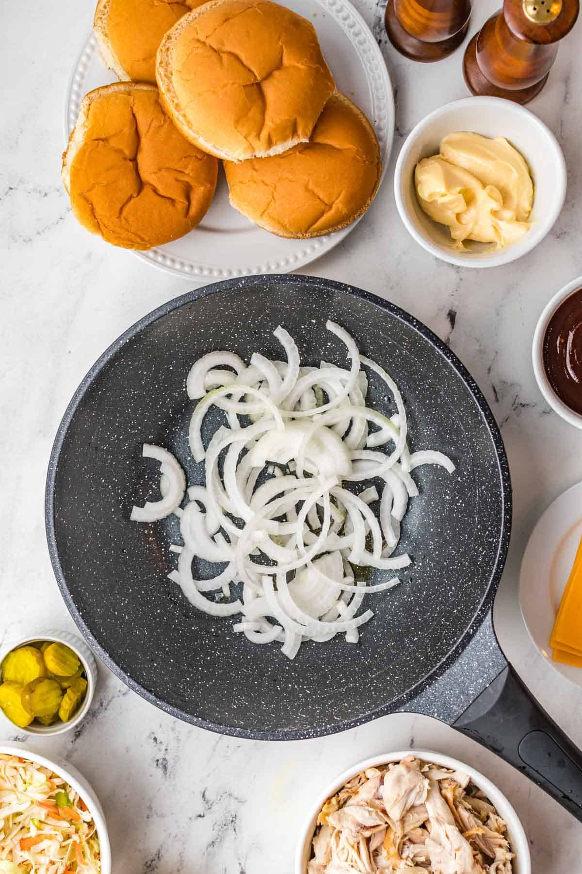 Raw onions are in a skillet.