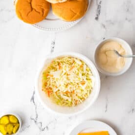 Coleslaw is presented in a white bowl.