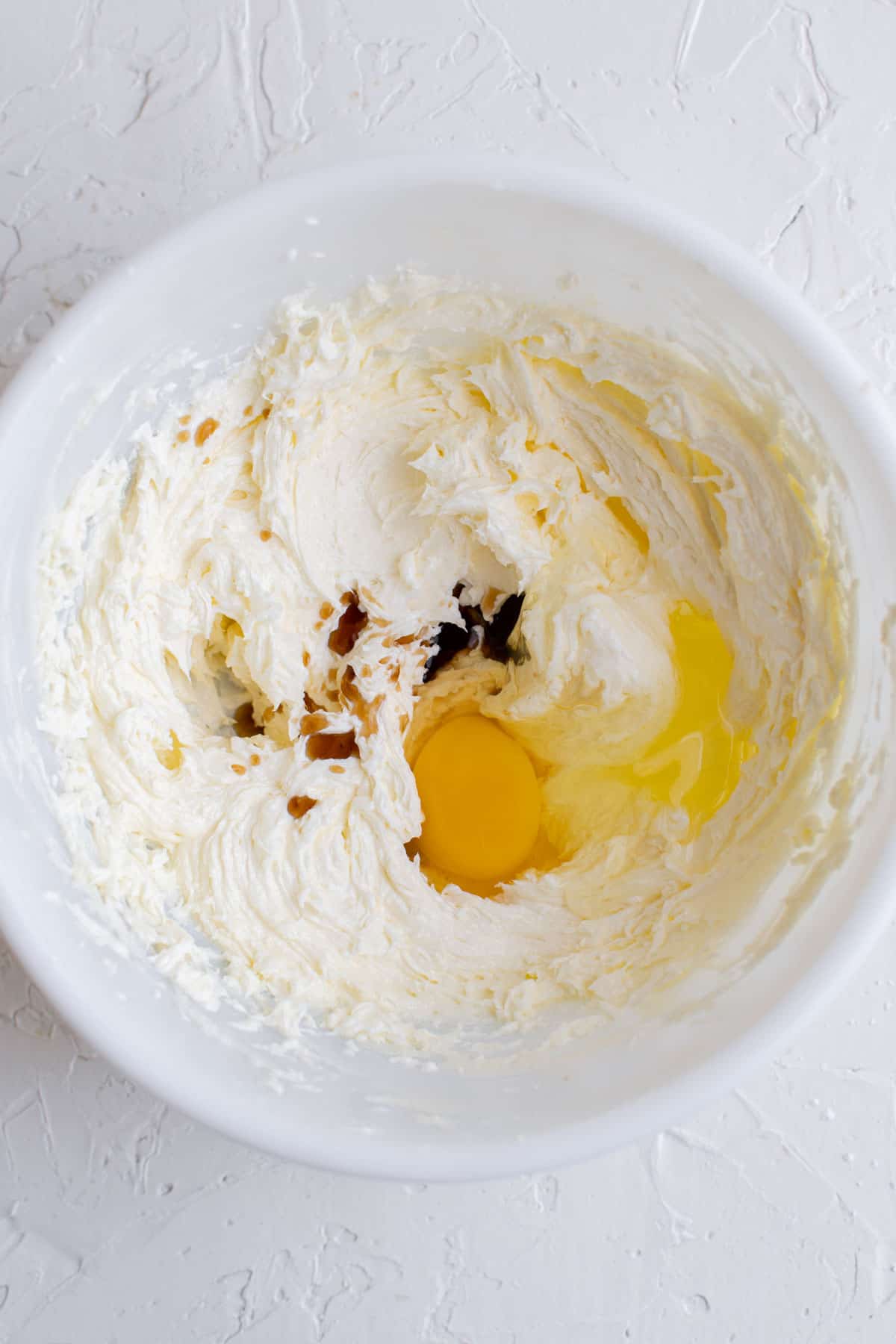 egg, vanilla extract, and creamed butter in a white bowl