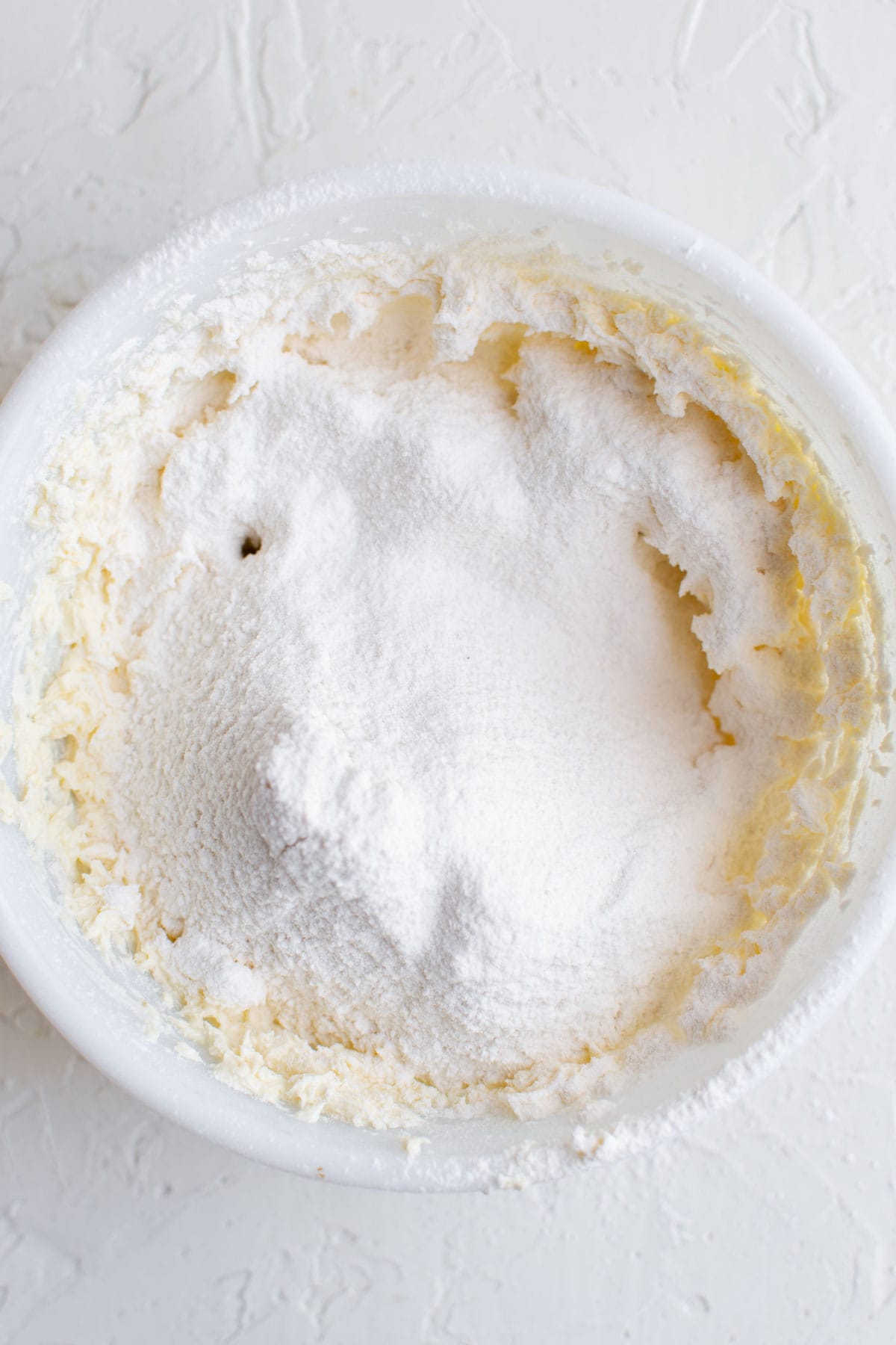 whipped butter and sifted powdered sugar in a white bowl