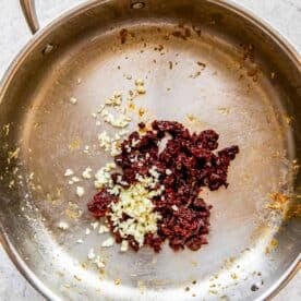 garlic and sun-dried tomatoes in a stainless steel skillet