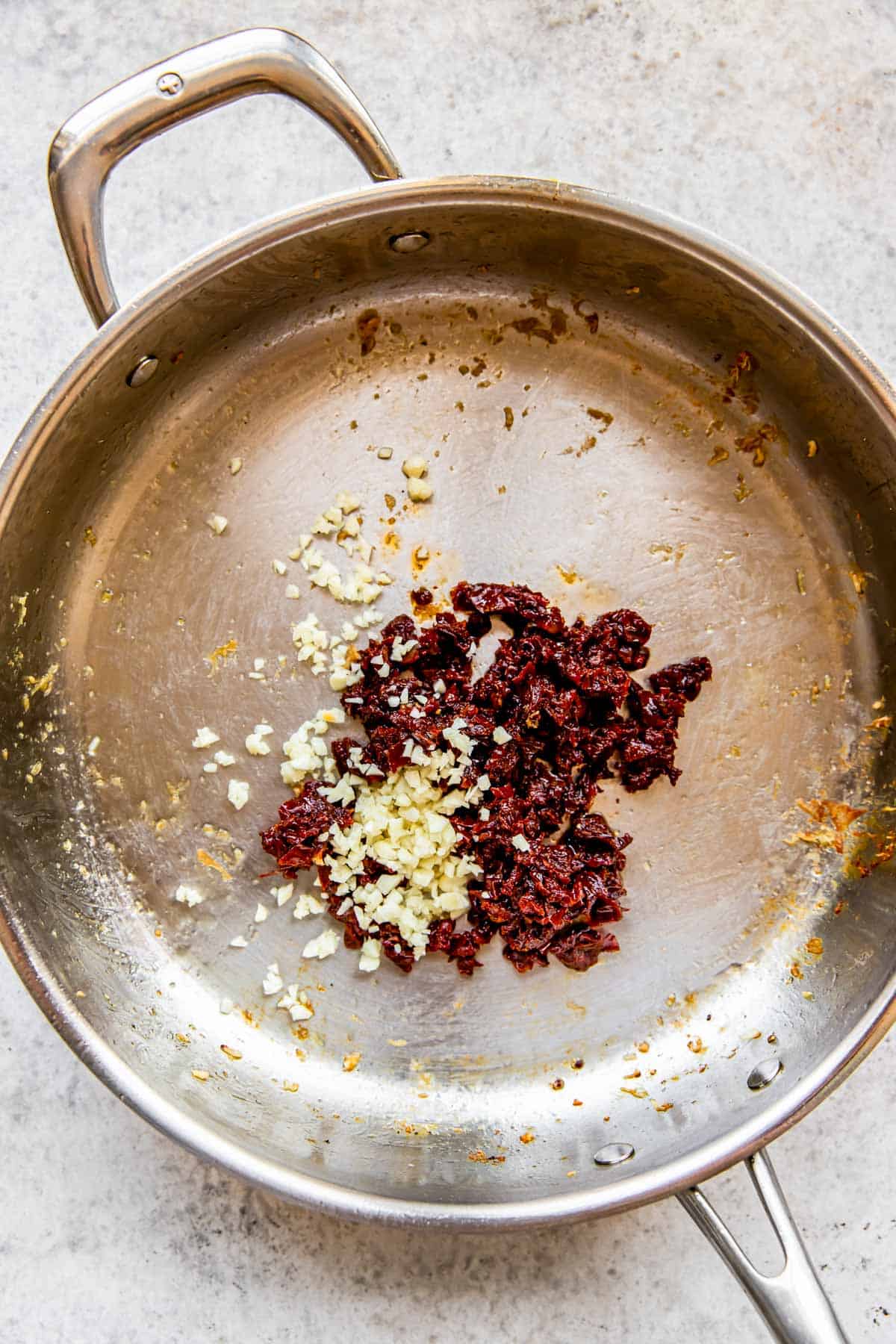 garlic and sun-dried tomatoes in a stainless steel skillet