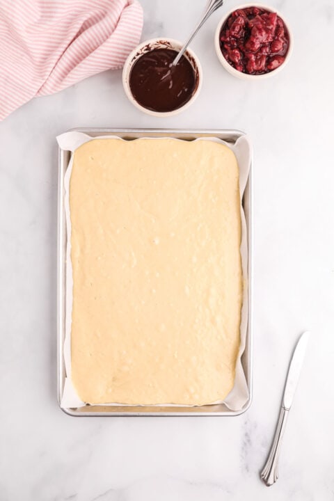 batter for pancakes poured into a parchment paper lined metal sheet pan