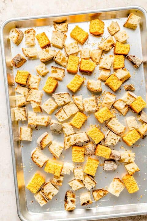 cornbread and sourdough squares on a metal baking sheet
