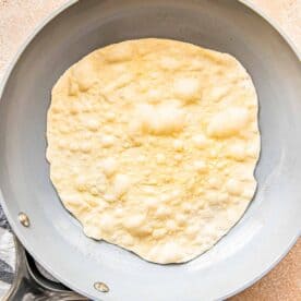 a bubbling surface of a flour tortilla is in a nonstick skillet