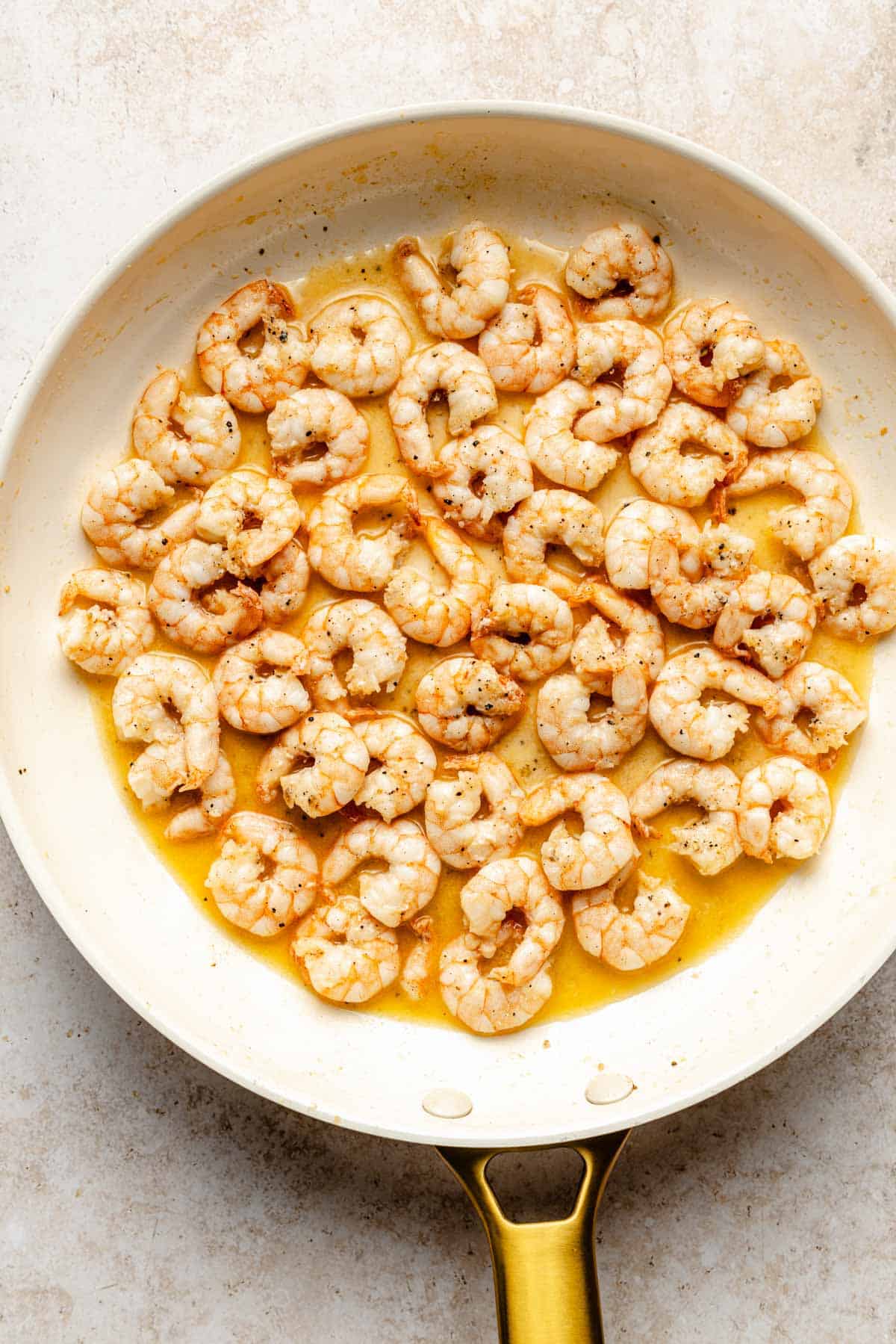 shrimp being cooked in a skillet with butter