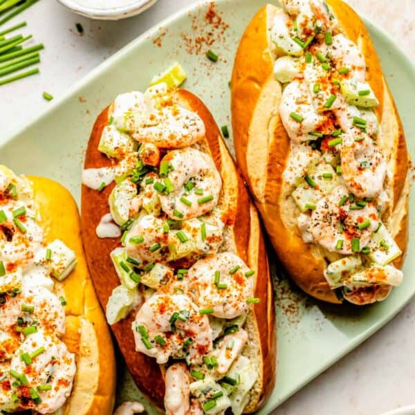 overhead image of shrimp rolls on a green plate sprinkled with fresh chives on top