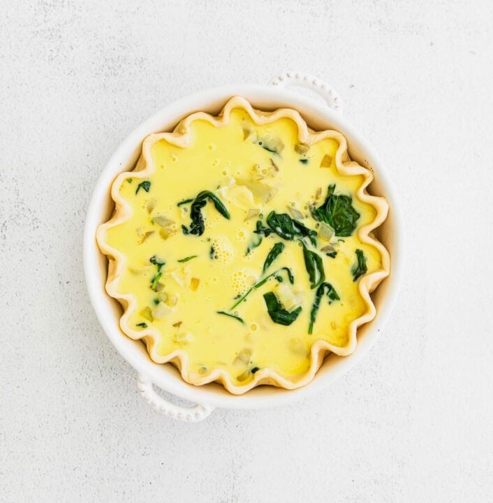 egg added to spinach and artichoke mixture in pie crust