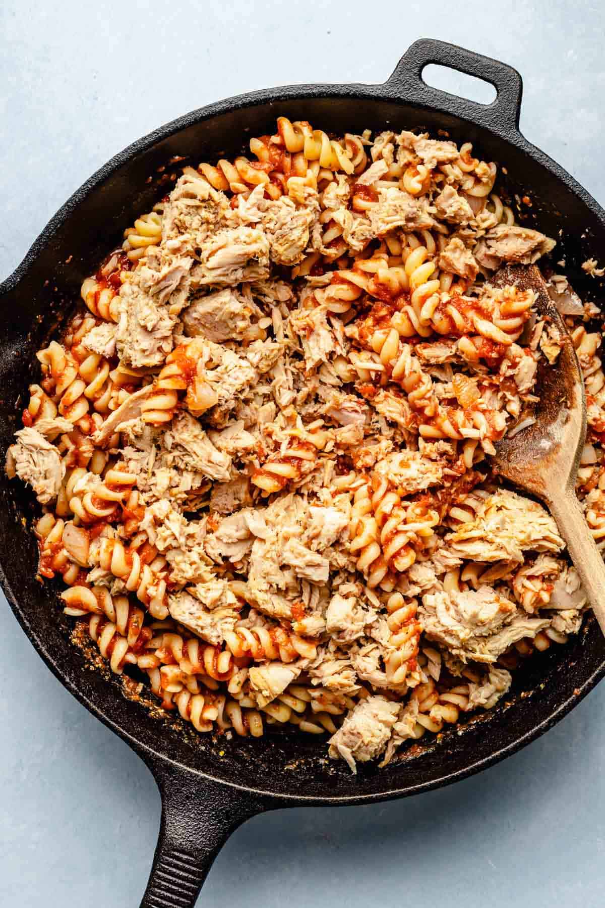 pasta and canned tuna fish added to the cast iron skillet with the tomato sauce.