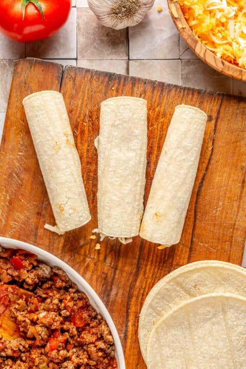 corn tortillas rolled with seam side down on a cutting board