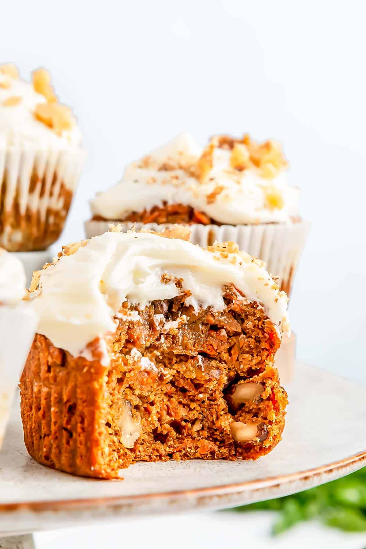 a bite has been taken out of a carrot cake muffin to display the insides of the cake