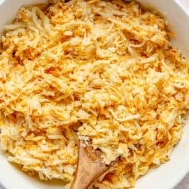 thawed shredded hashbrown potatoes mixed together with cheese and cream of chicken mixture in a large bowl