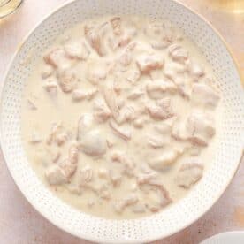 chicken thigh pieces marinating in a flour mixture