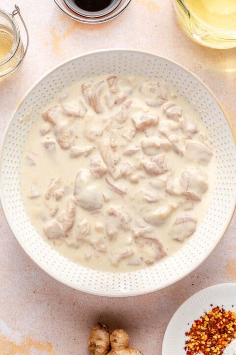 chicken thigh pieces marinating in a flour mixture