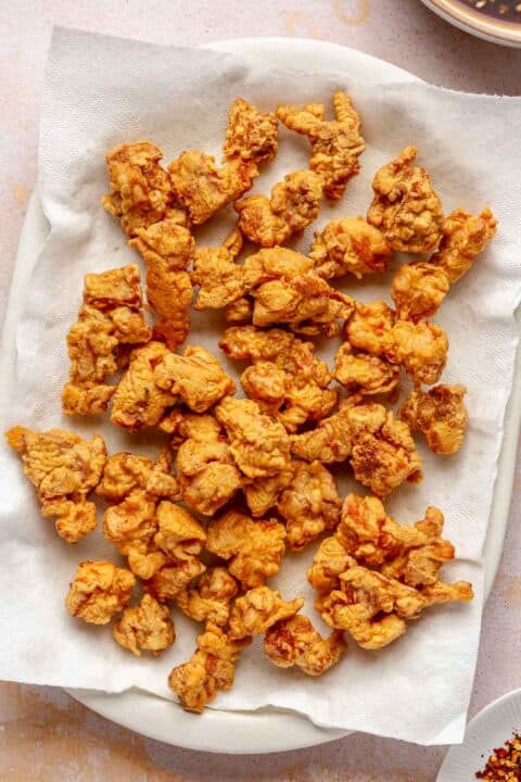 deep fried chicken pieces on a paper towel-lined plate