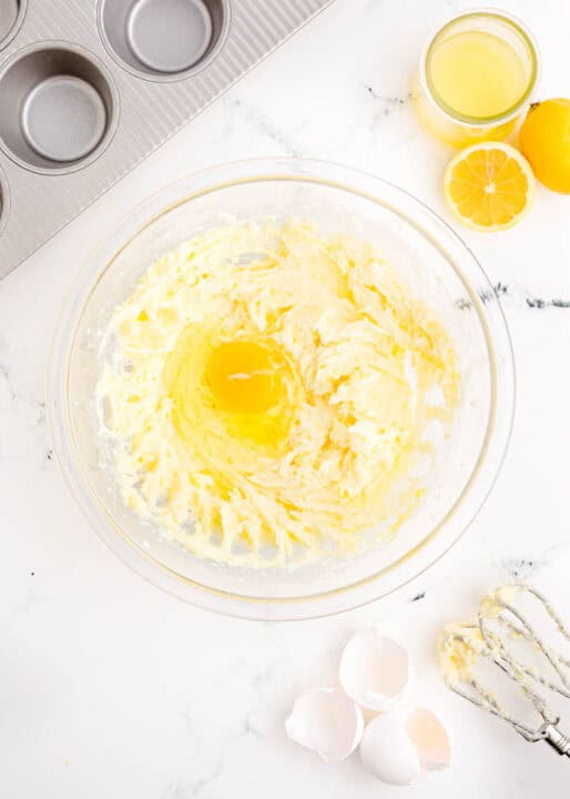 an egg is added to the butter and sugar mixture in a clear bowl
