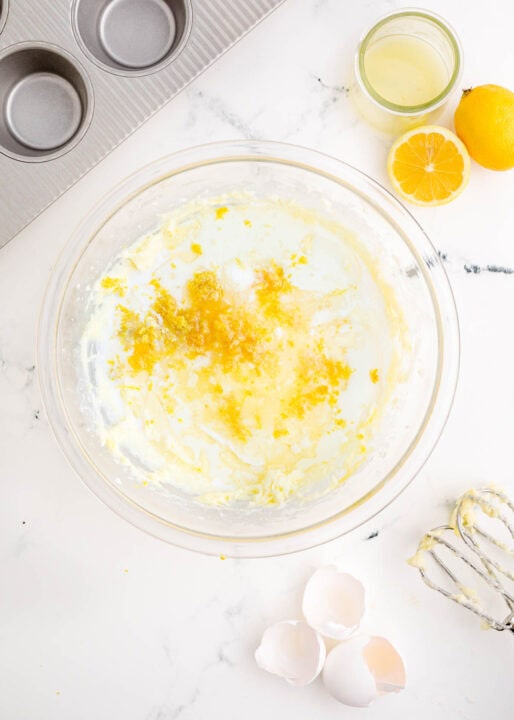 lemon zest and other liquids are added to the batter in a clear bowl