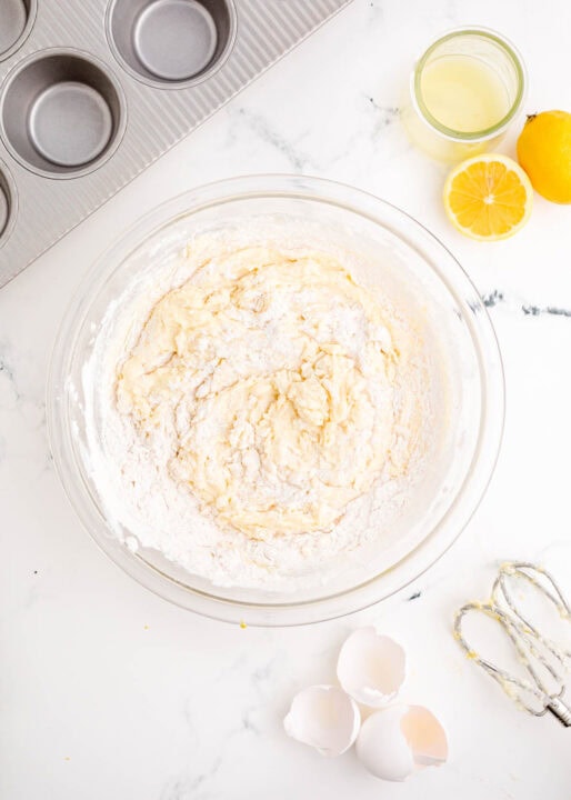 dry and wet ingredients are being mixed together in a clear bowl