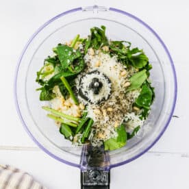 ingredients for basil pesto in the bowl of a food processor