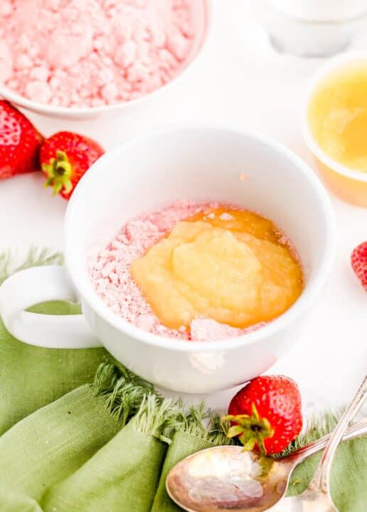 applesauce on top of strawberry cake mix in a white mug