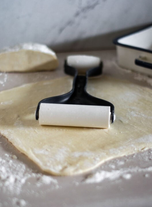 flattening out pie crust dough with a pastry tool
