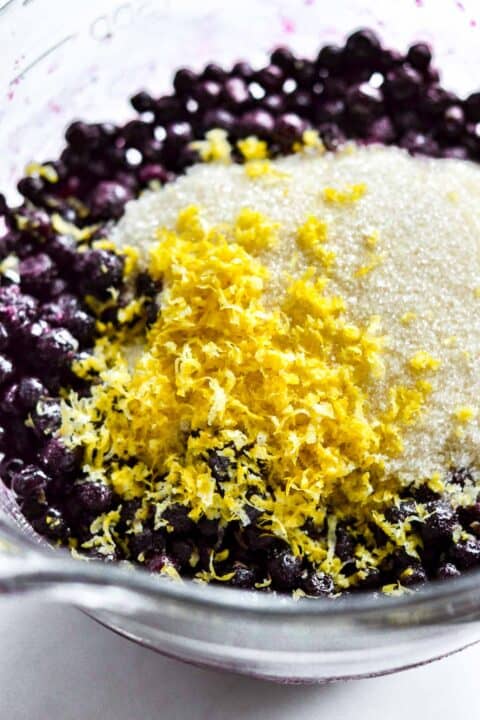 lemon zest, granulated sugar, and wild blueberries in a clear bowl
