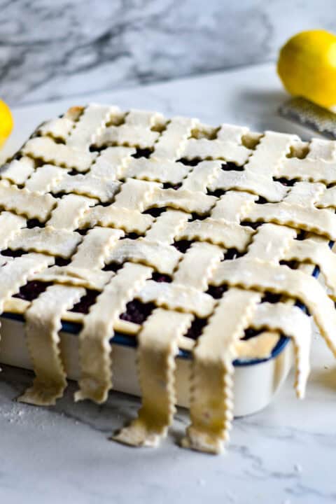 pastry dough strips draped over baking dish in a lattice design