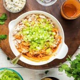 buffalo chicken mixture with fresh celery in a white bowl