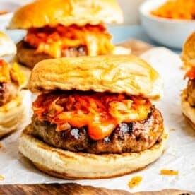 bulgogi kimchi burger topped with kimchi and gochujang mayo on parchment paper