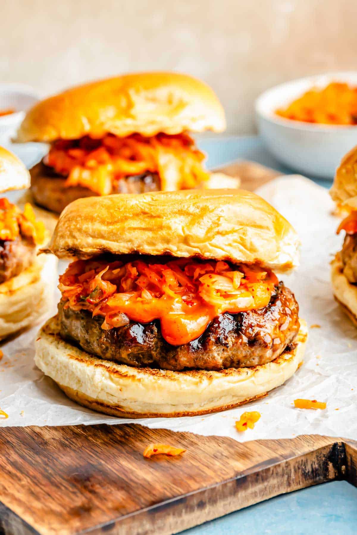 bulgogi kimchi burger topped with kimchi and gochujang mayo on parchment paper