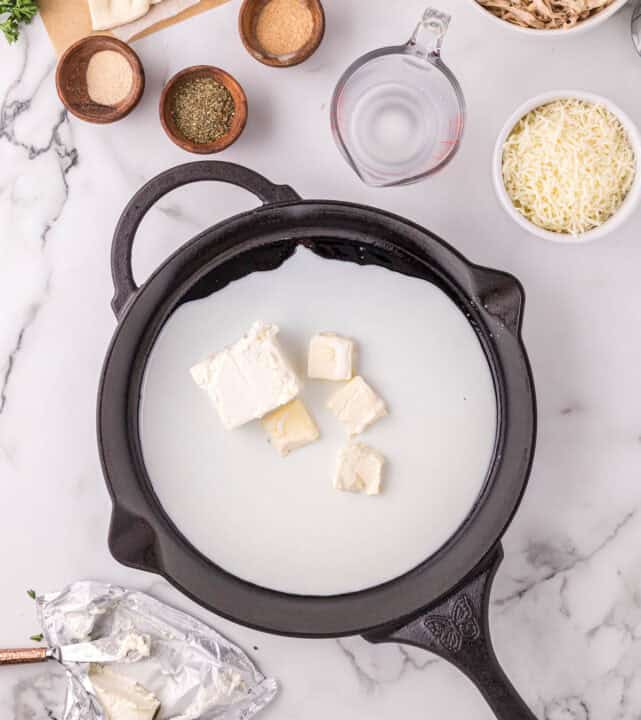 milk, butter, and cream cheese in a cast iron skillet