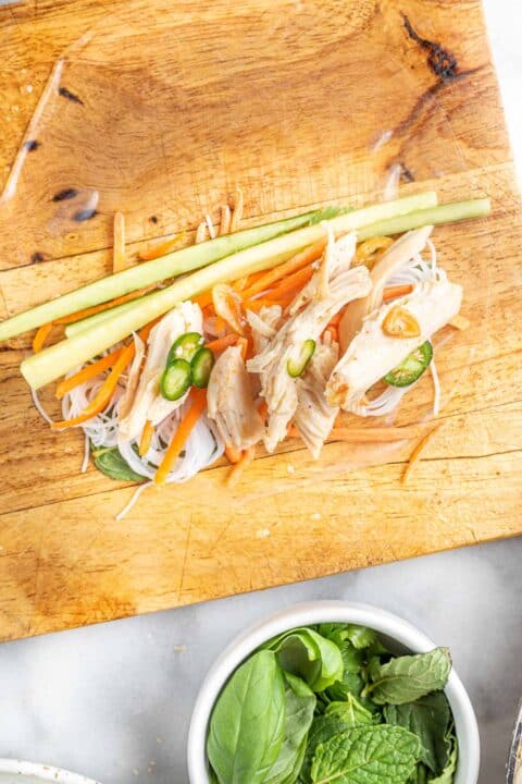 ingredients for chicken summer rolls on top of softened rice paper wrap