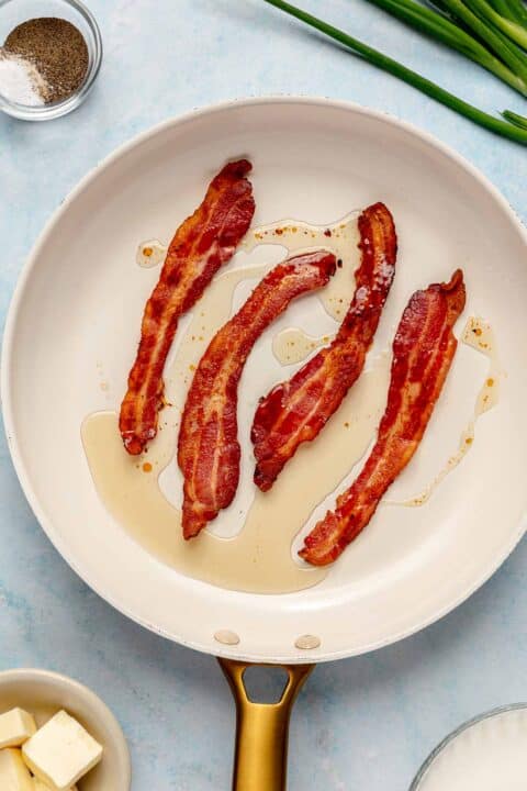4 strips of cooked bacon in a skillet