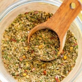 greek seasoning in a clear bowl with a wooden spoon