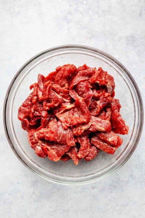 thinly sliced flank steak in a clear bowl
