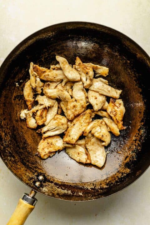 thinly sliced chicken breast cooked in a wok
