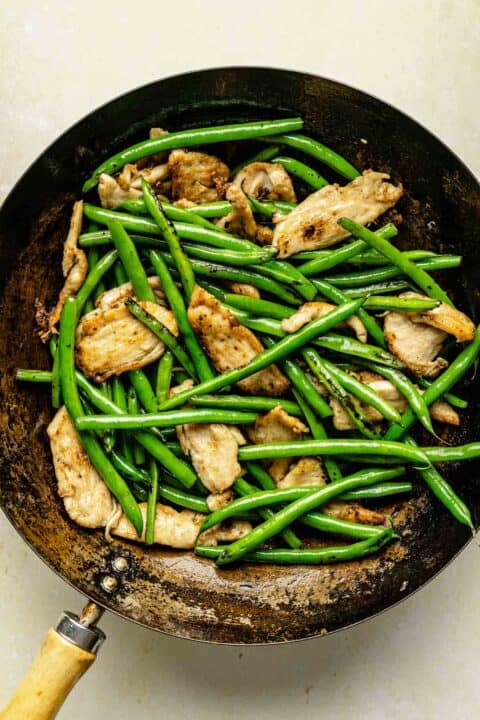 green beans and chicken in a wok
