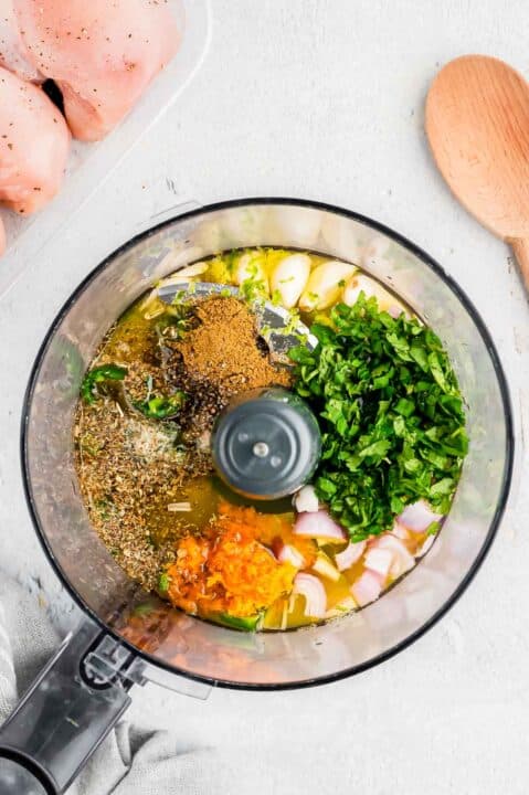 ingredients for mojo chicken marinade in the bowl of a food processor