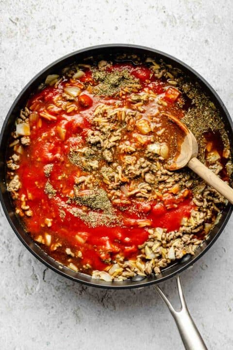 tomato sauce and beef broth added to a nonstick skillet with orzo and ground beef
