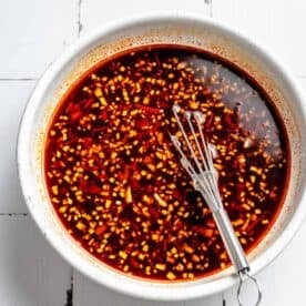 ingredients for shrimp stir fry sauce in a bowl with a small metal whisk